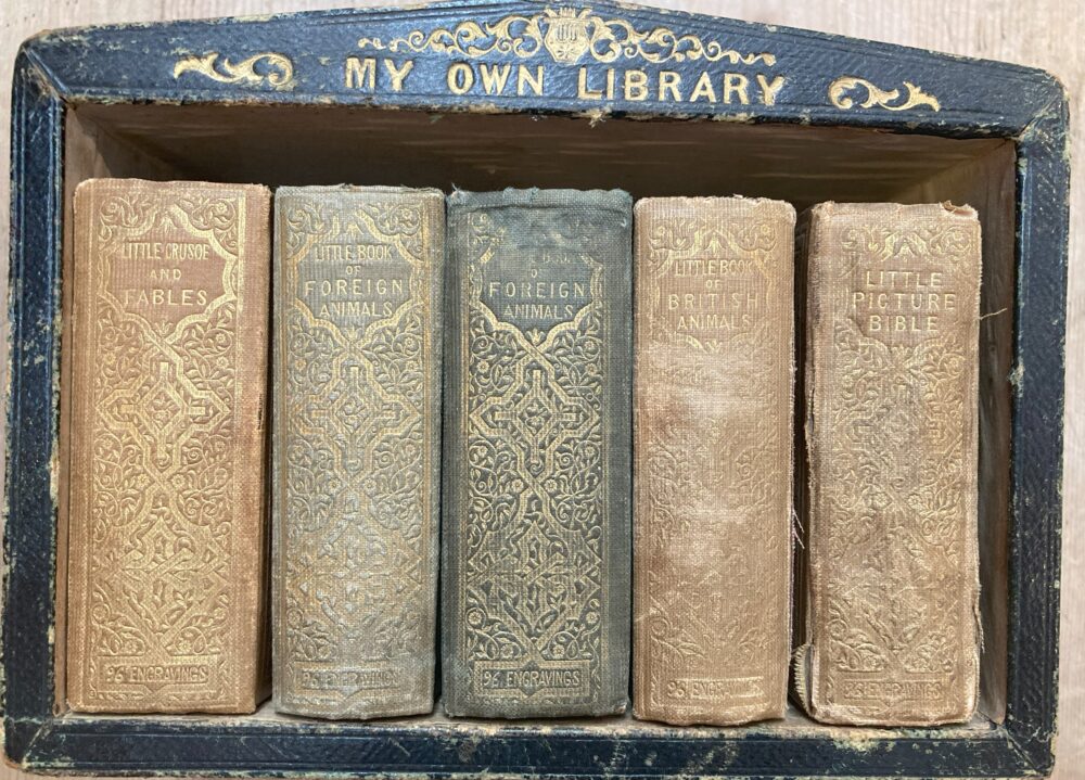 Box containing five miniature books.